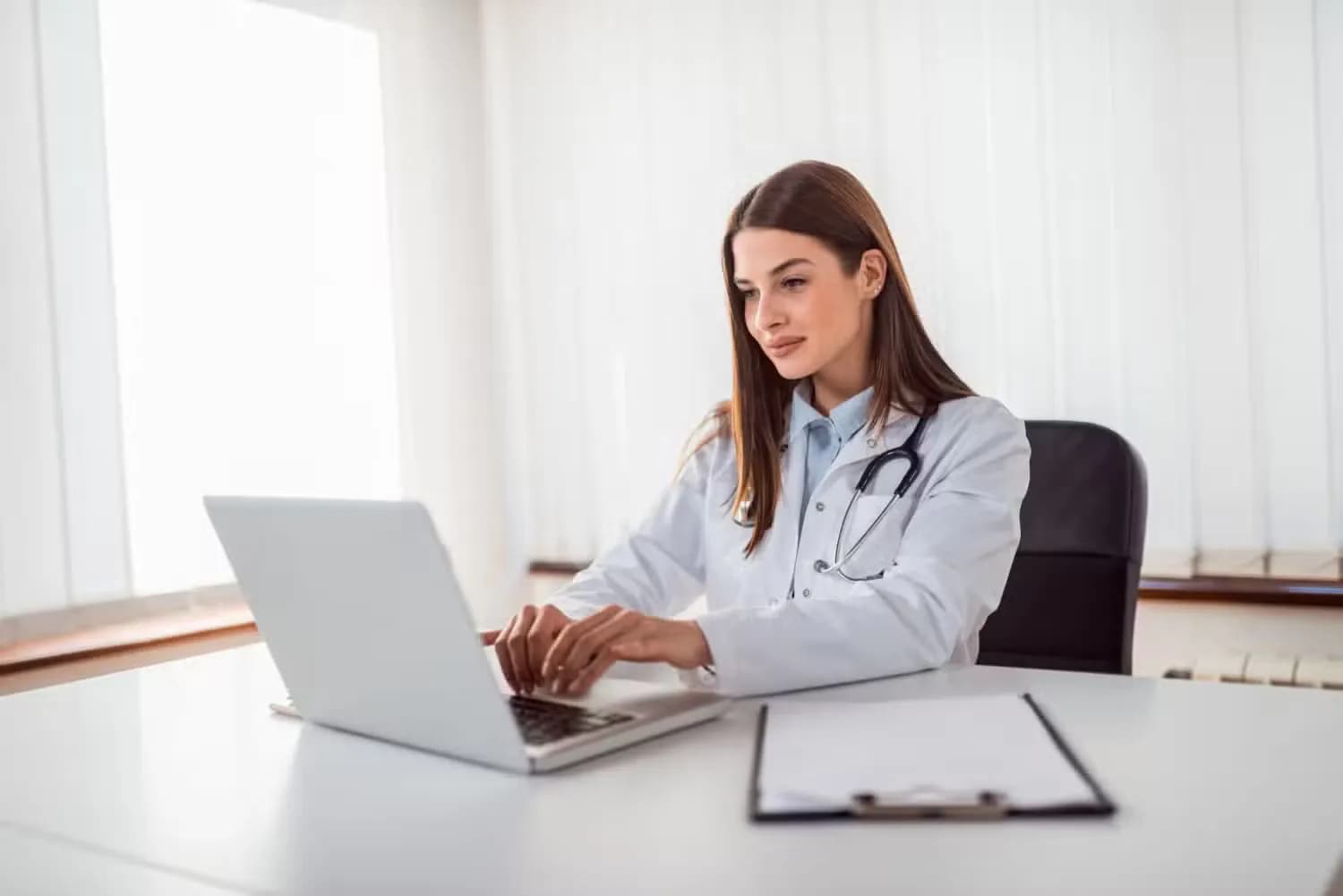 Médica utilizando o laptop para estudar conteúdo do CONAES